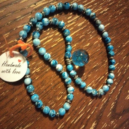 Blue beaded necklace with wisp
